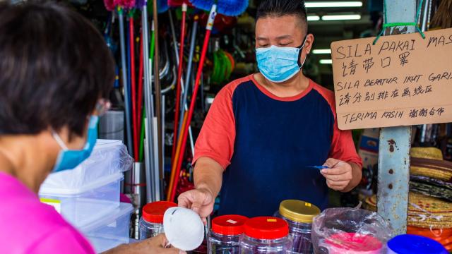 A shopkeeper asks customers to always wear a mask when buying from his store. Photo credit: iStock/Kong Ding Chek.