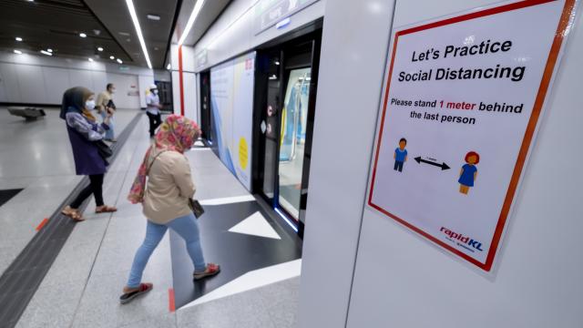 Commuters wear a face mask and practice social distancing at the MRT station in Kuala Lumpur. iStock/razaklatif