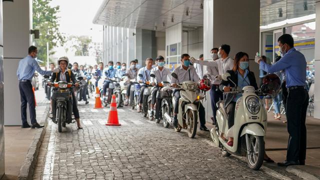 A line of motorcycle riders waiting to be tested