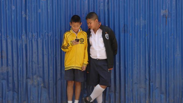 Two children browsing through a smartphone 