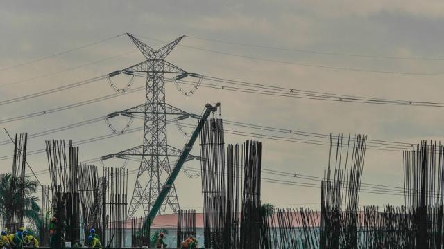 Construction workers at a job site in the Philippines against a backdrop of electricity transmission lines. Photo credit: ADB.