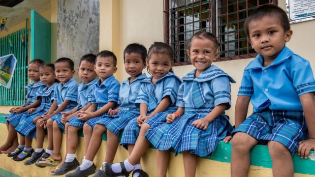 Young students wait outside their classroom in Mindanao. Photo credit: Asian Development Bank.