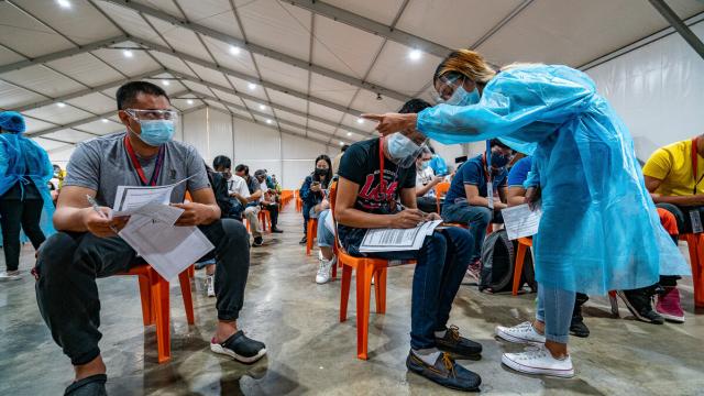 A health worker inoculating a patient with the COVID-19 vaccine. 