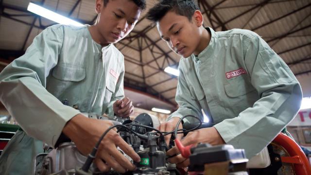 Students in a training center in Indonesia work on a car equipment.