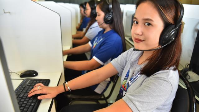 Female students using computers during class in the Philippines.