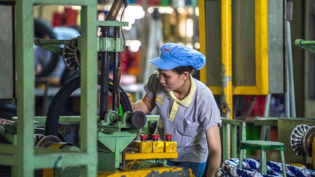 A factory worker inspects a tire on the assembly line.