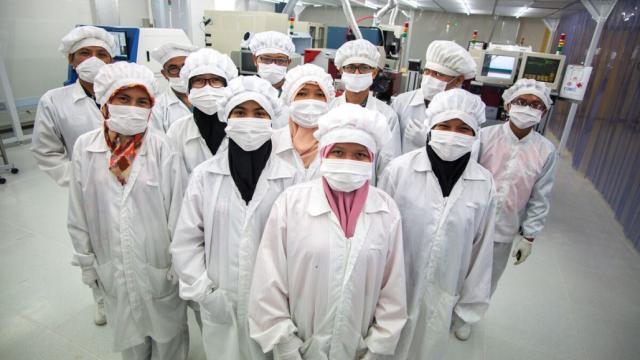 	Students and instructors at the Batam State Polytechnic's teaching factory work to mass-produce PCB's and microchips. The acquisition of this expensive production equipment was made possible through funding from the Asian Development Bank. Photo credit: ADB.